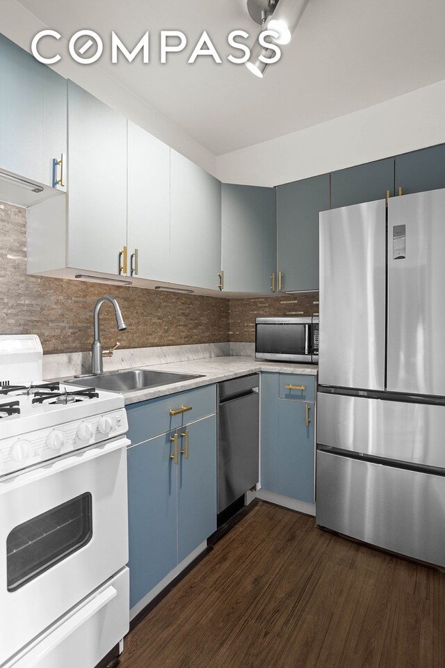 kitchen featuring dark hardwood / wood-style flooring, sink, blue cabinetry, and appliances with stainless steel finishes