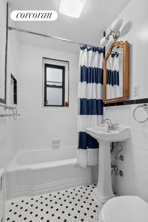 bathroom featuring tile patterned floors, toilet, tile walls, and shower / bath combo