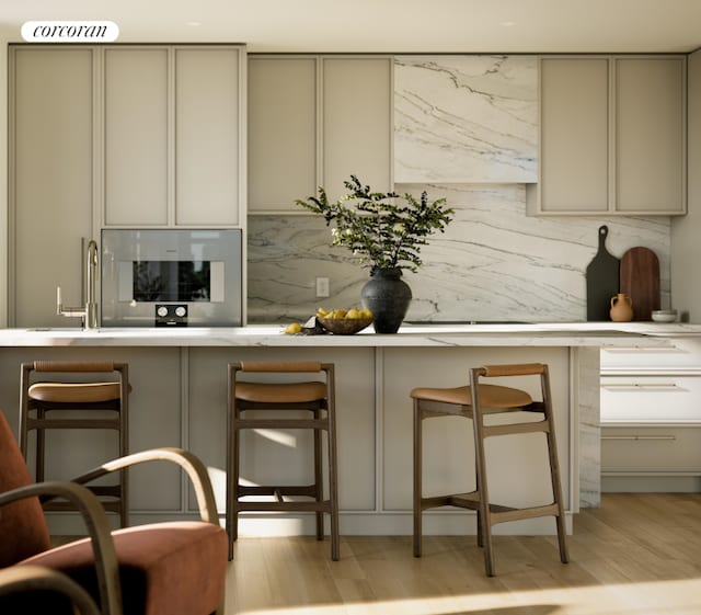 bar with backsplash, oven, gray cabinets, and light wood-type flooring