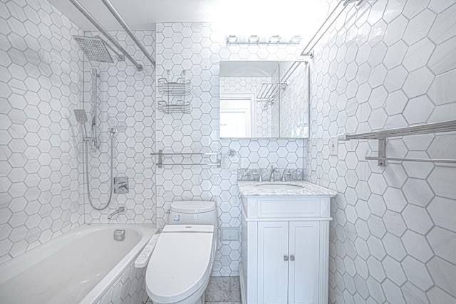 bathroom with tiled shower / bath combo, tile walls, toilet, and vanity