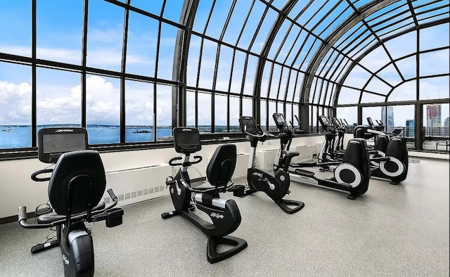 workout area featuring a water view and a towering ceiling