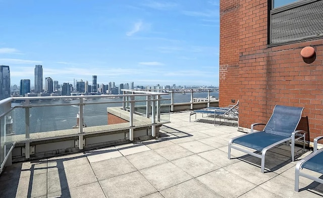 view of patio featuring a water view and a balcony