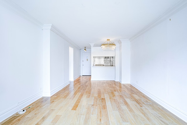 unfurnished living room featuring light wood finished floors, baseboards, ornamental molding, and a chandelier