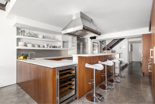 bar featuring wine cooler, bar, a sink, island exhaust hood, and finished concrete floors