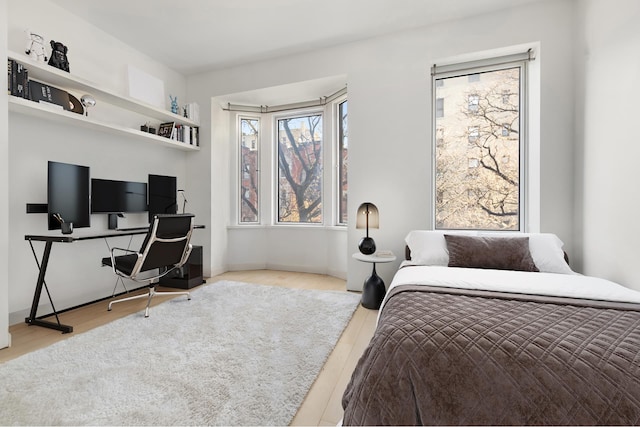 bedroom with baseboards and wood finished floors