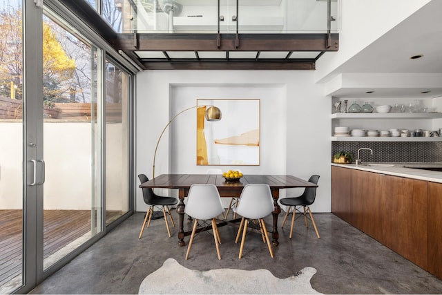 dining space featuring concrete floors and indoor wet bar