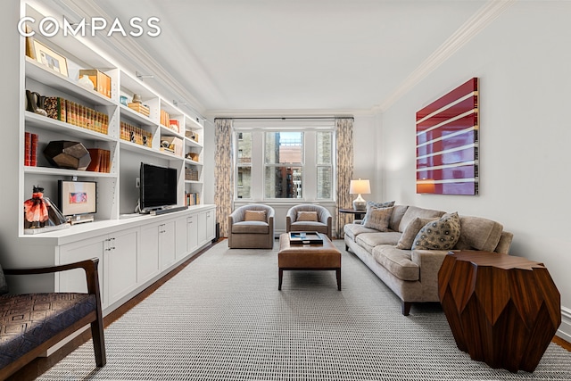 living room featuring crown molding, baseboards, and wood finished floors