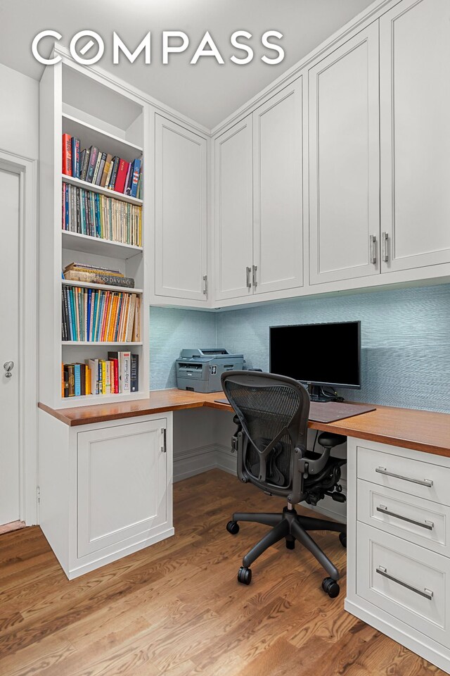 office space with light wood finished floors and built in desk