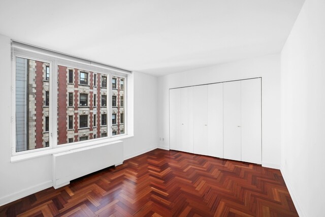 unfurnished living room with dark parquet flooring