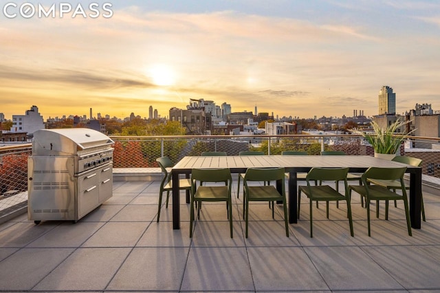 patio terrace at dusk featuring grilling area