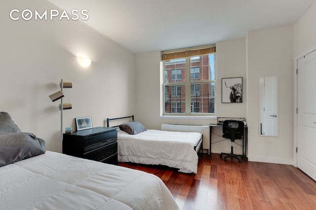 bedroom featuring wood finished floors and baseboards