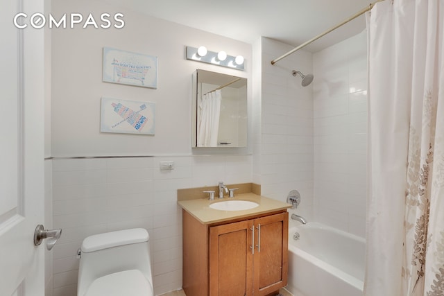 bathroom featuring toilet, vanity, tile walls, wainscoting, and shower / tub combo with curtain