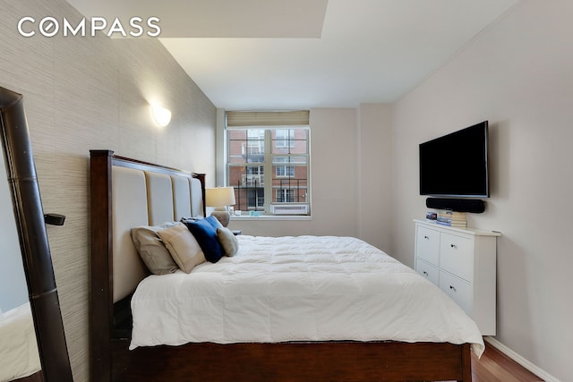 bedroom featuring baseboards and wood finished floors