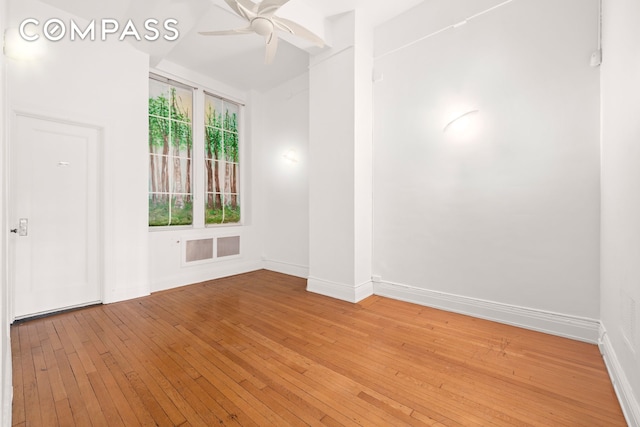 spare room featuring light wood finished floors, baseboards, and a ceiling fan