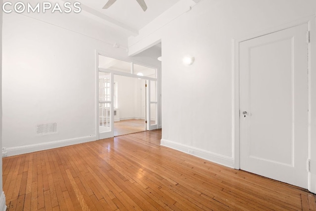 unfurnished room with hardwood / wood-style flooring, ceiling fan, and beamed ceiling