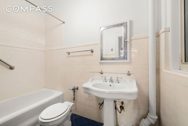 bathroom featuring toilet, tile patterned flooring, and tile walls