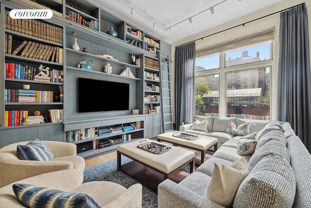 living area with built in shelves and wood finished floors