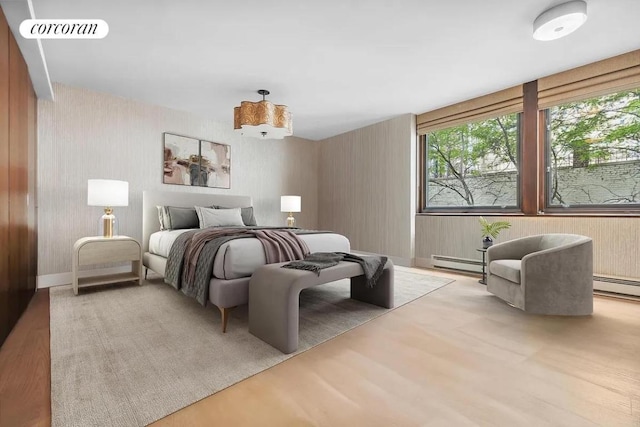 bedroom with light wood-type flooring and a baseboard radiator