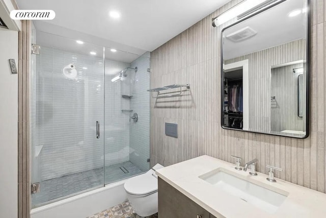 bathroom featuring a shower with shower door, vanity, and toilet