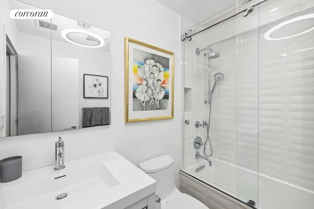 full bathroom featuring toilet, vanity, and shower / bath combination with glass door