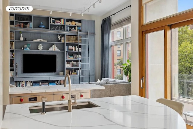 interior space featuring light stone countertops and sink