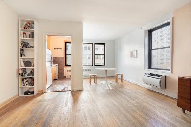 interior space with heating unit, radiator, and light hardwood / wood-style floors