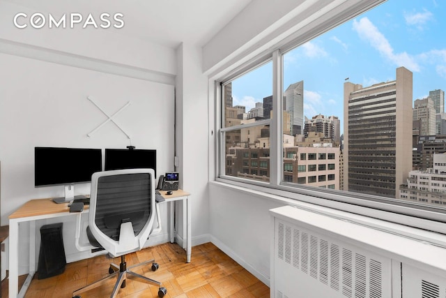 office area featuring baseboards and radiator