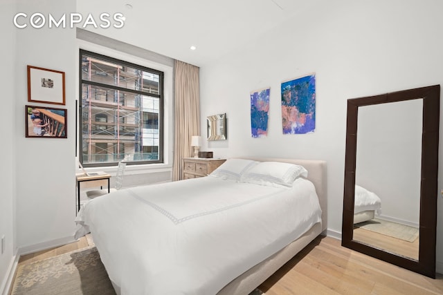 bedroom with recessed lighting, light wood-style flooring, and baseboards