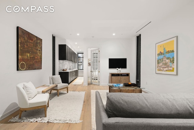 living area with recessed lighting, light wood-type flooring, and baseboards