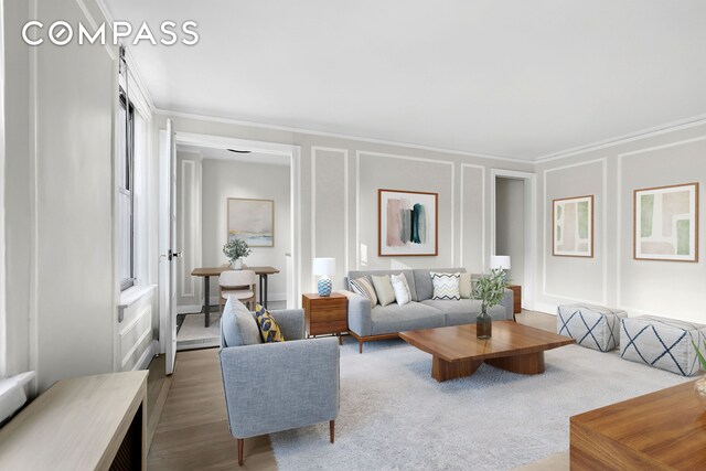 living room featuring wood-type flooring and ornamental molding