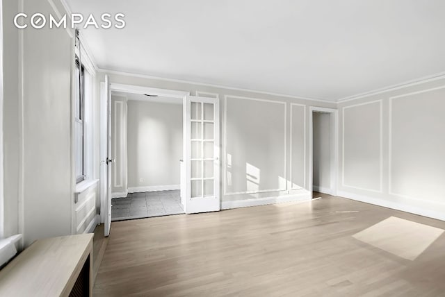 spare room with wood-type flooring and ornamental molding