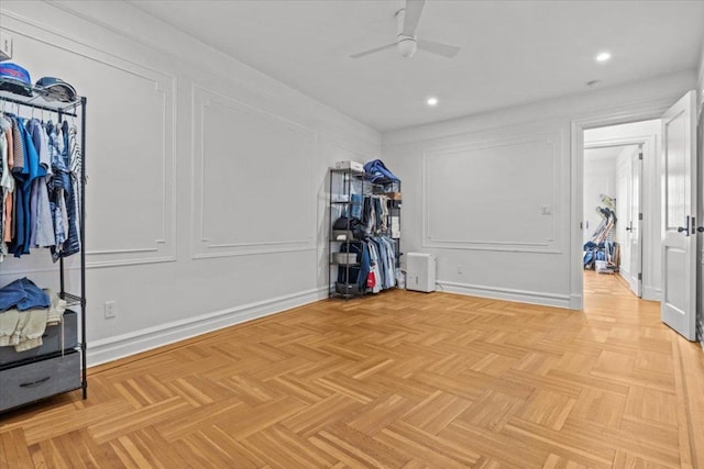 interior space with ceiling fan and a decorative wall