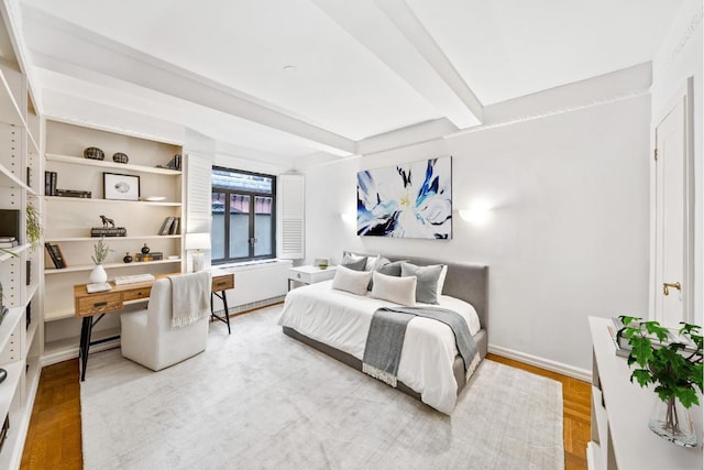 bedroom featuring wood-type flooring and beamed ceiling