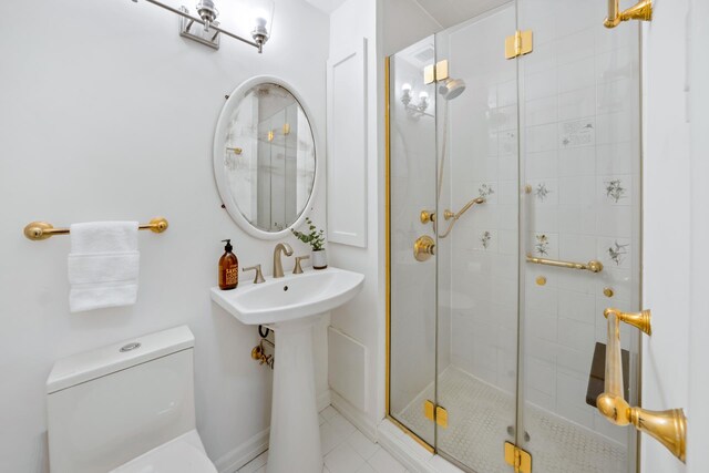 bathroom featuring toilet, a shower with door, and tile patterned flooring