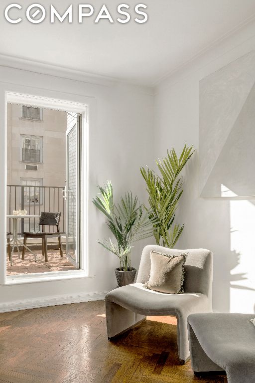 living area with ornamental molding and parquet floors