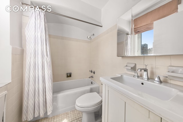 full bathroom featuring tile patterned floors, toilet, vanity, tile walls, and shower / tub combo with curtain