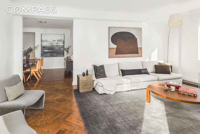 living area with baseboards and crown molding