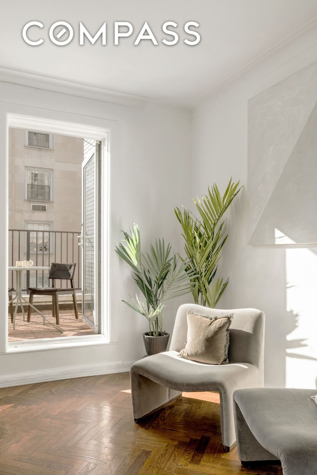 sitting room with baseboards and ornamental molding
