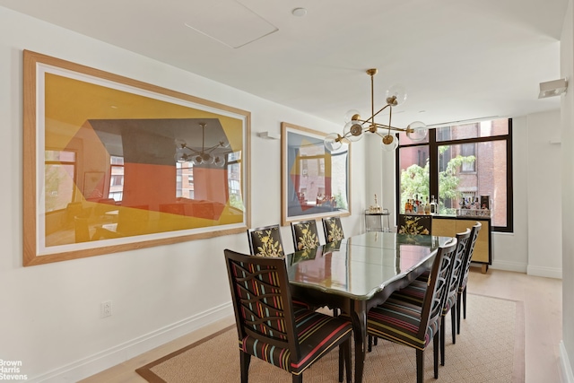 dining area featuring an inviting chandelier, baseboards, and wood finished floors