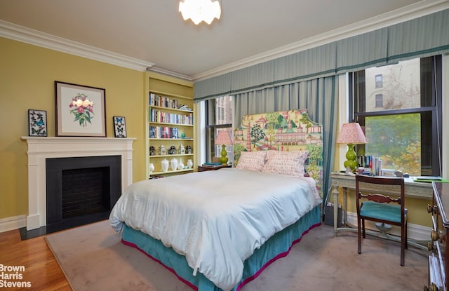 bedroom featuring baseboards, a fireplace, ornamental molding, and wood finished floors