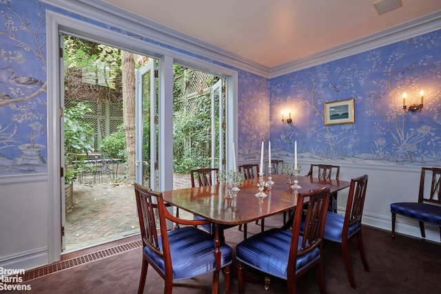 dining area featuring crown molding and wallpapered walls