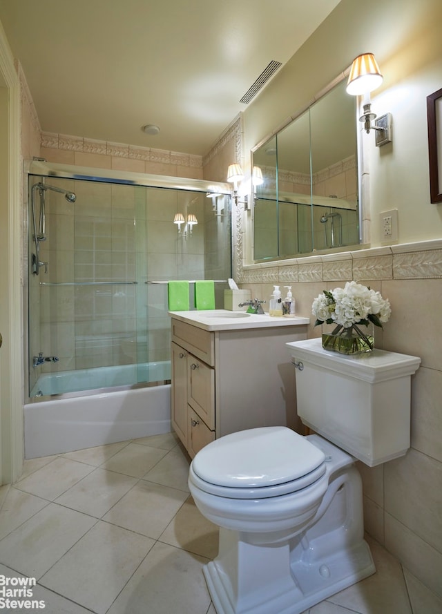 bathroom featuring tile walls, visible vents, toilet, enclosed tub / shower combo, and tile patterned flooring