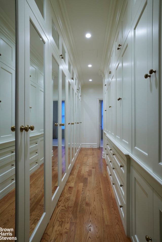 corridor with baseboards, recessed lighting, light wood-type flooring, and crown molding