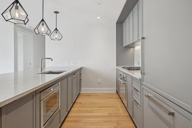 kitchen with pendant lighting, gray cabinets, and sink