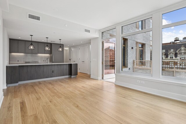 unfurnished living room with sink and light wood-type flooring