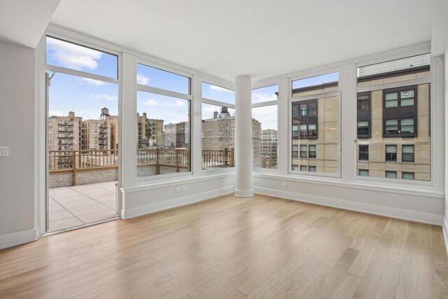 218 W 103rd St Unit 11D, New York City, NY 10025 - unfurnished sunroom with a view of city, baseboards, and wood finished floors