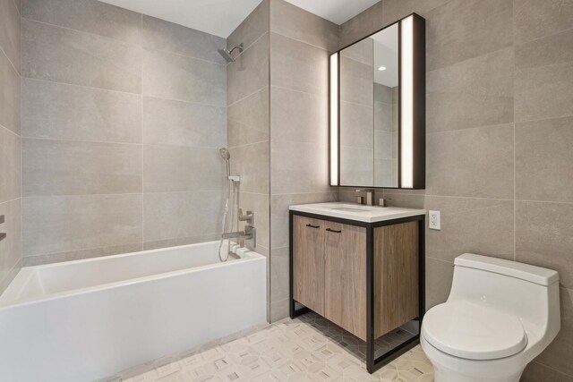 218 W 103rd St Unit 11D, New York City, NY 10025 - bathroom with toilet, tile walls, shower / bathing tub combination, and vanity