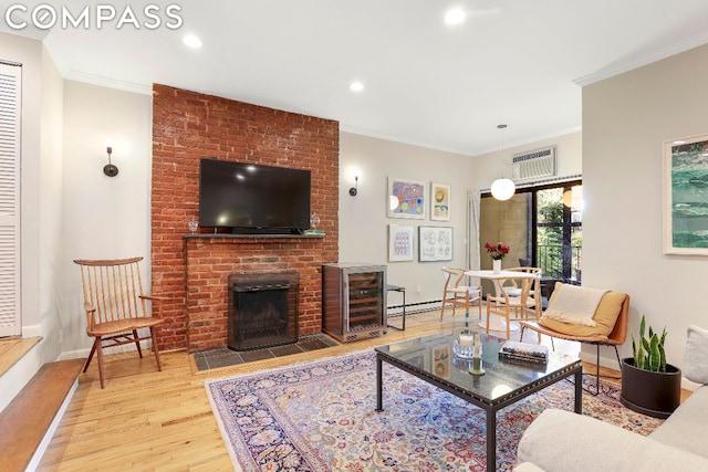 living room with light hardwood / wood-style floors, crown molding, and a fireplace