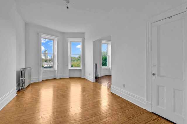 interior space with radiator, wood-type flooring, and baseboards