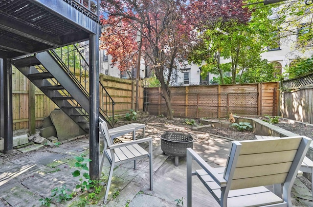 view of patio / terrace with a fenced backyard, a fire pit, and stairs